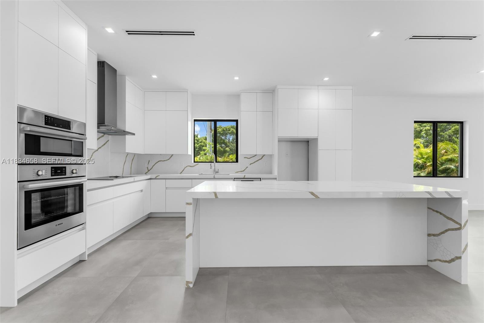 8220 Southwest 193rd Terrace Cutler Bay, FL 33157 - Photo 11 of 59 a kitchen with stainless steel appliances a stove sink microwave and window