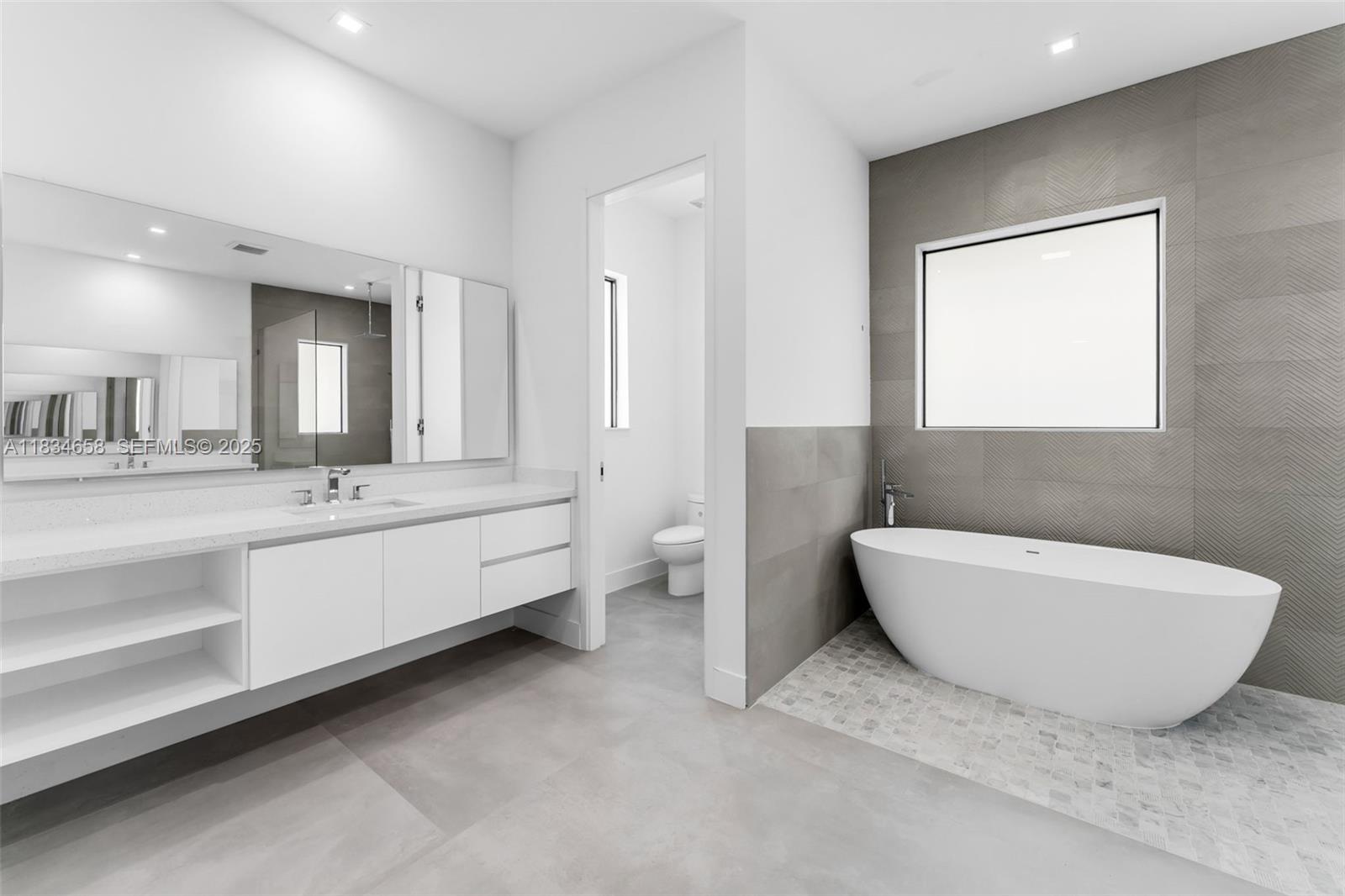 8220 Southwest 193rd Terrace Cutler Bay, FL 33157 - Photo 25 of 59 a bathroom with a bathtub a toilet a sink and mirror