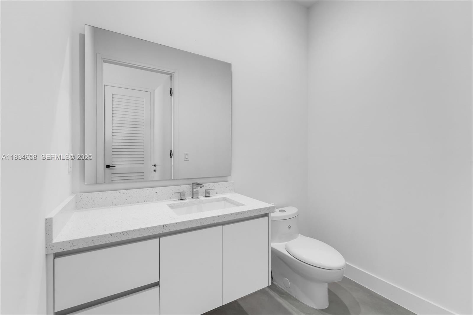 8220 Southwest 193rd Terrace Cutler Bay, FL 33157 - Photo 35 of 59 a bathroom with a sink a toilet and mirror