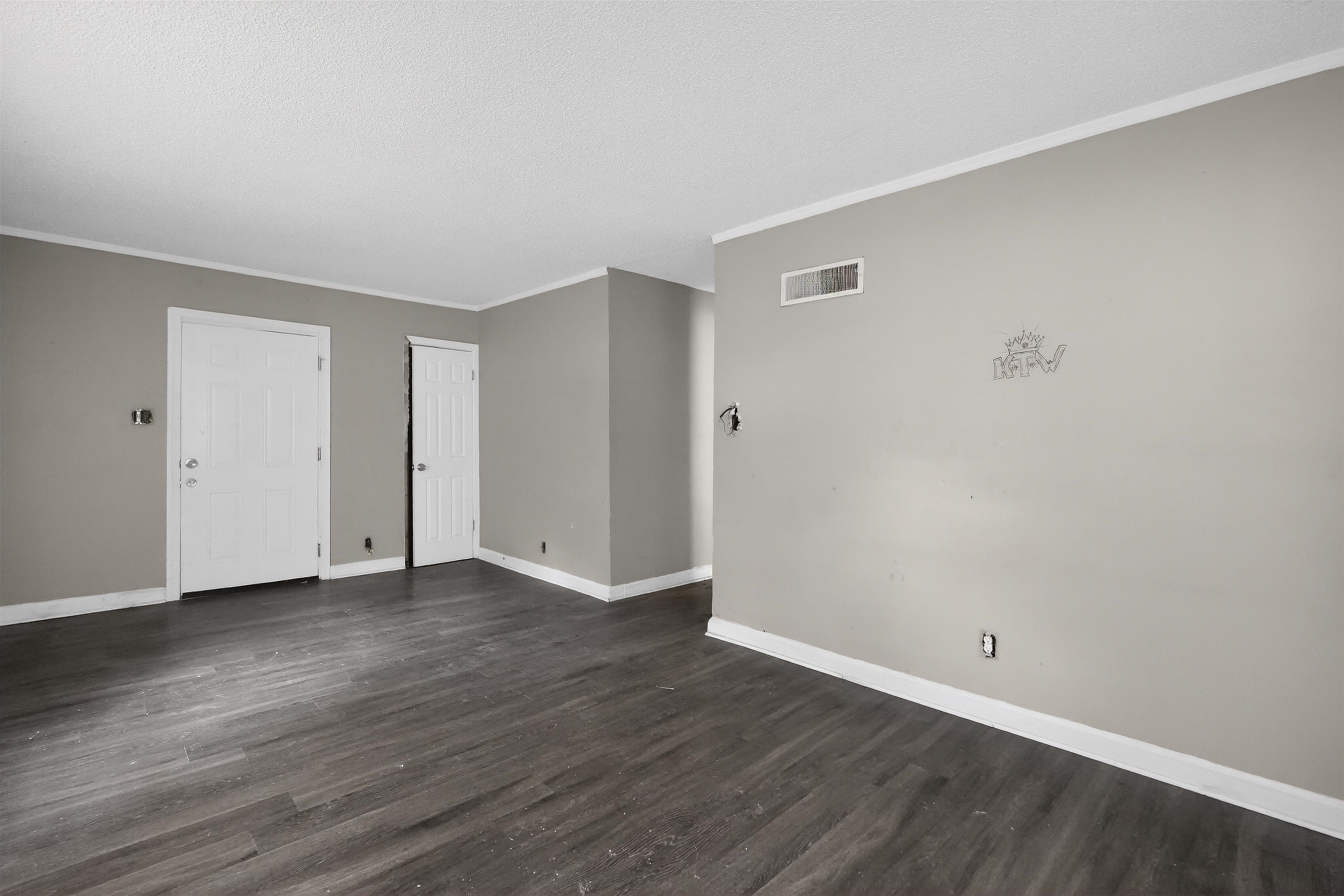 949 Sumter Street Memphis, TN 38122 - Photo 16 of 33 Spacious room featuring dark wood-finish flooring, light gray wall paint, white trim, and two paneled doors
