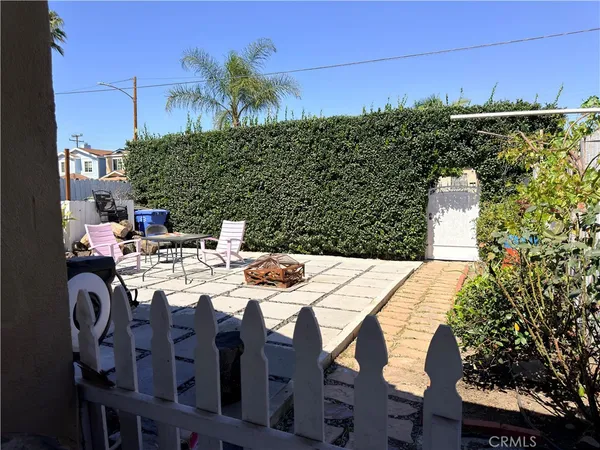 a backyard of a house with plants and wooden fence