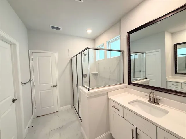 a bathroom with a double vanity sink mirror and shower