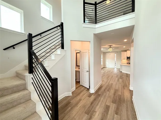 a view of a hallway with wooden floor and staircase