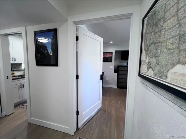 a view of a hallway with wooden floor and windows