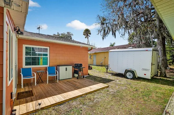 a view of roof deck with table and chairs a barbeque with wooden fence