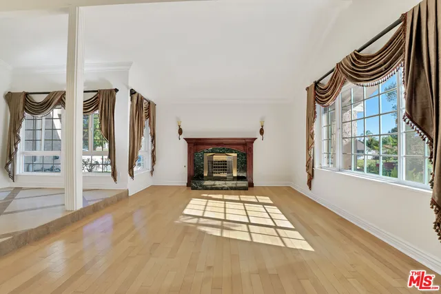 a view of an empty room with a fireplace and a window