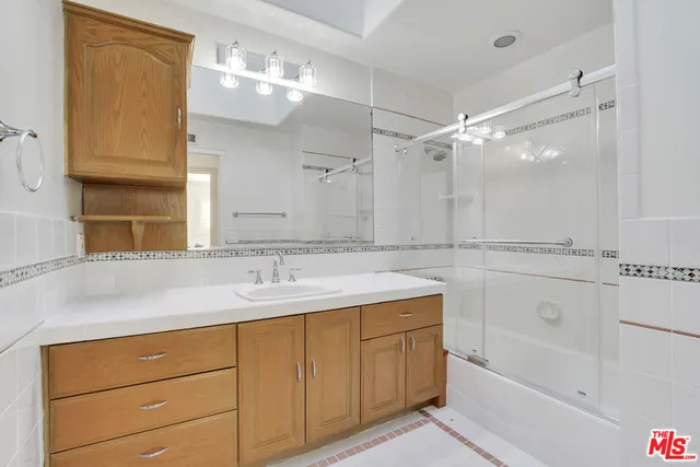 a bathroom with a sink double vanity granite tub and shower