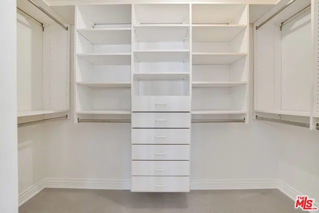 a view of walk in closet with empty racks