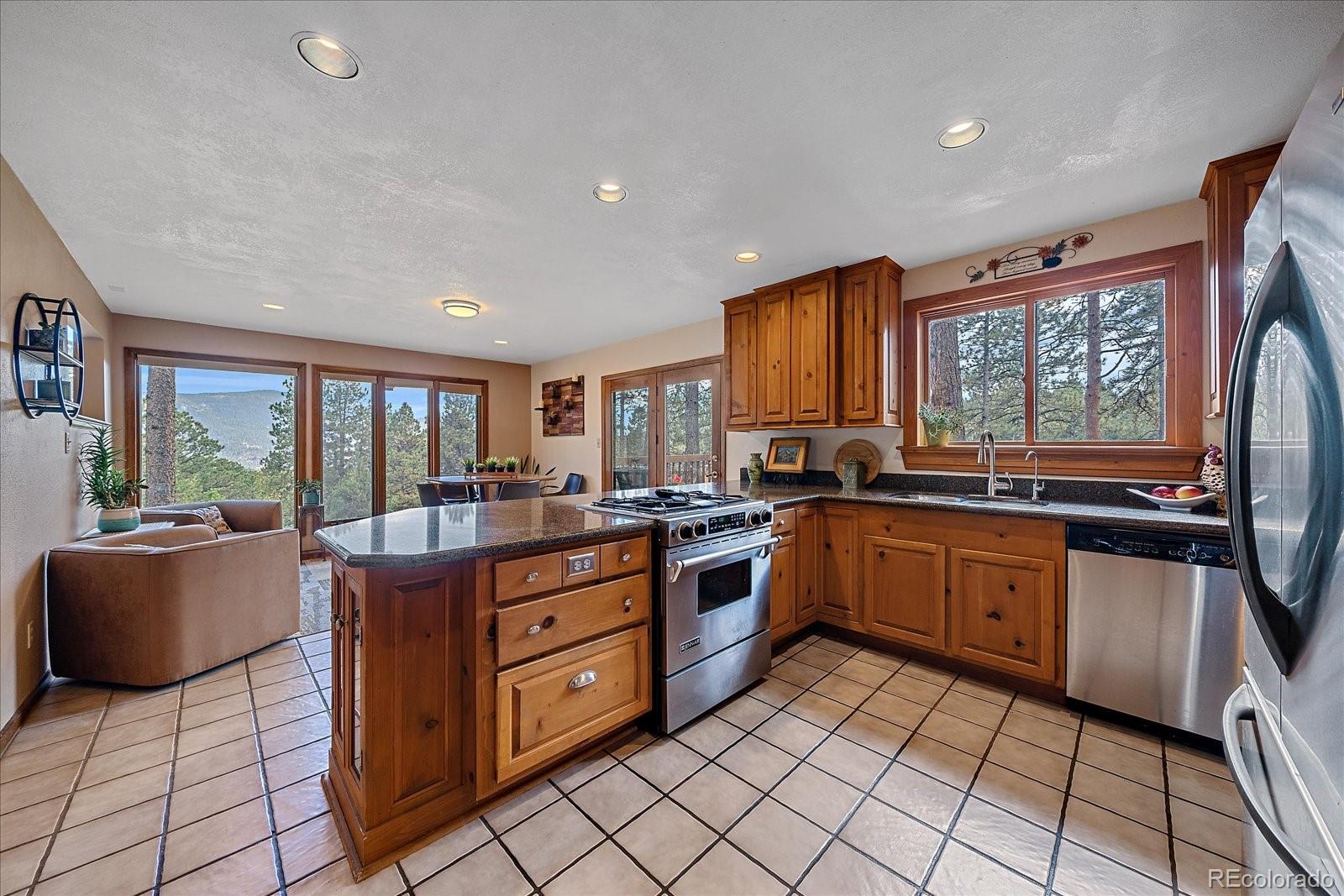 4059 Histead Way Evergreen, CO 80439 - Photo 12 of 37 a kitchen with stainless steel appliances granite countertop sink stove and granite counter top