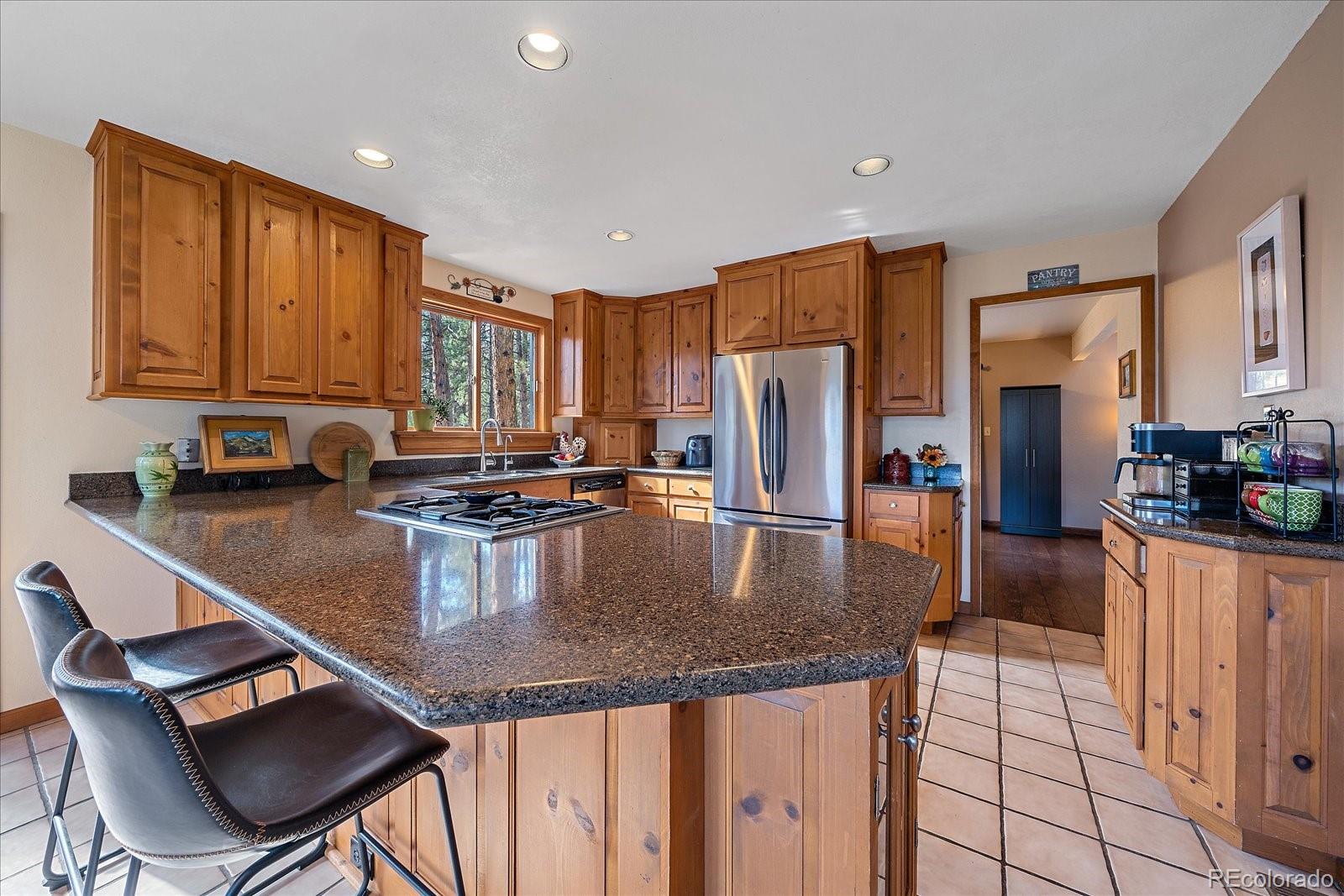 4059 Histead Way Evergreen, CO 80439 - Photo 13 of 37 a kitchen with stainless steel appliances granite countertop a stove top oven a refrigerator a sink and a stove