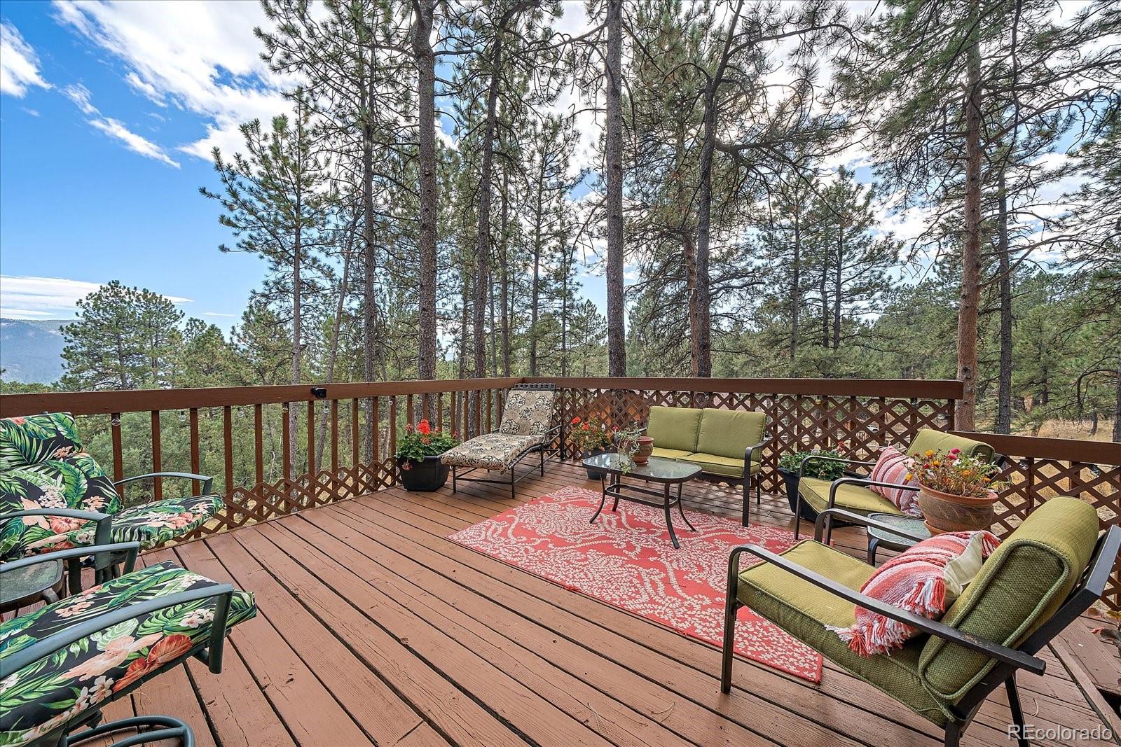 4059 Histead Way Evergreen, CO 80439 - Photo 20 of 37 a roof deck with wooden floor and outdoor seating