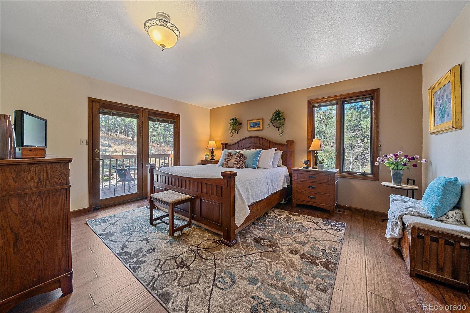 4059 Histead Way Evergreen, CO 80439 - Photo 21 of 37 a bedroom with a bed and wooden floor