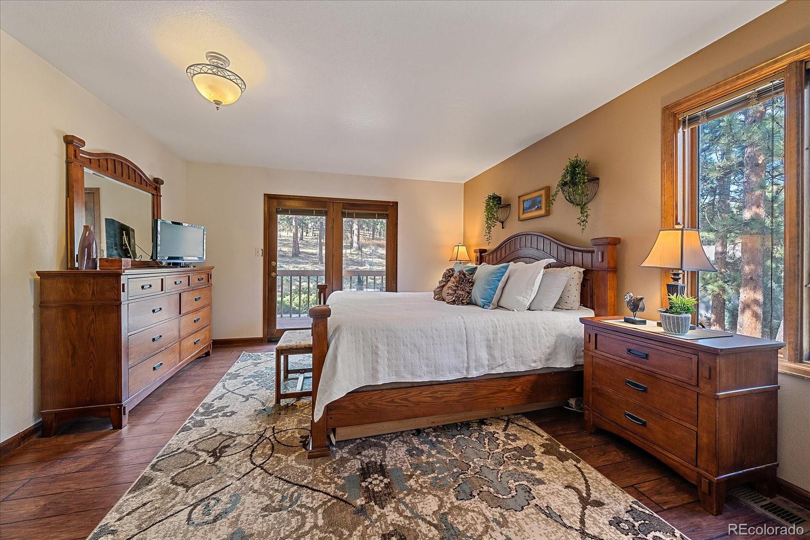 4059 Histead Way Evergreen, CO 80439 - Photo 22 of 37 a bedroom with a bed and a dresser next to a window