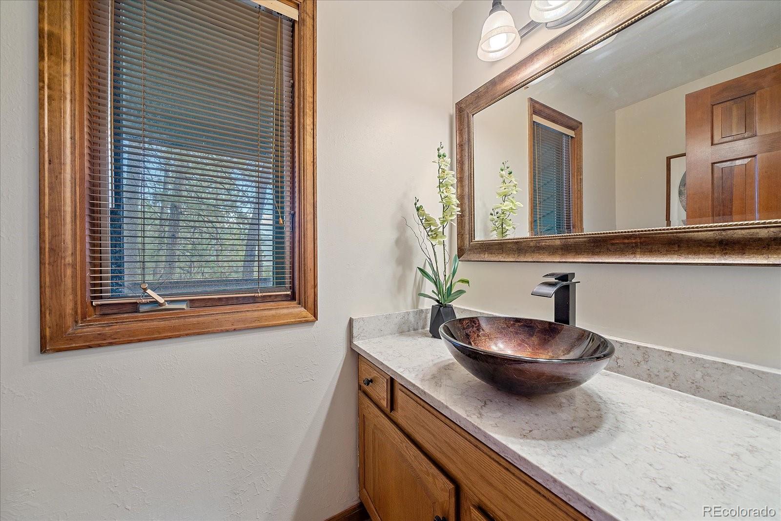 4059 Histead Way Evergreen, CO 80439 - Photo 24 of 37 a bathroom with a granite countertop sink and a mirror