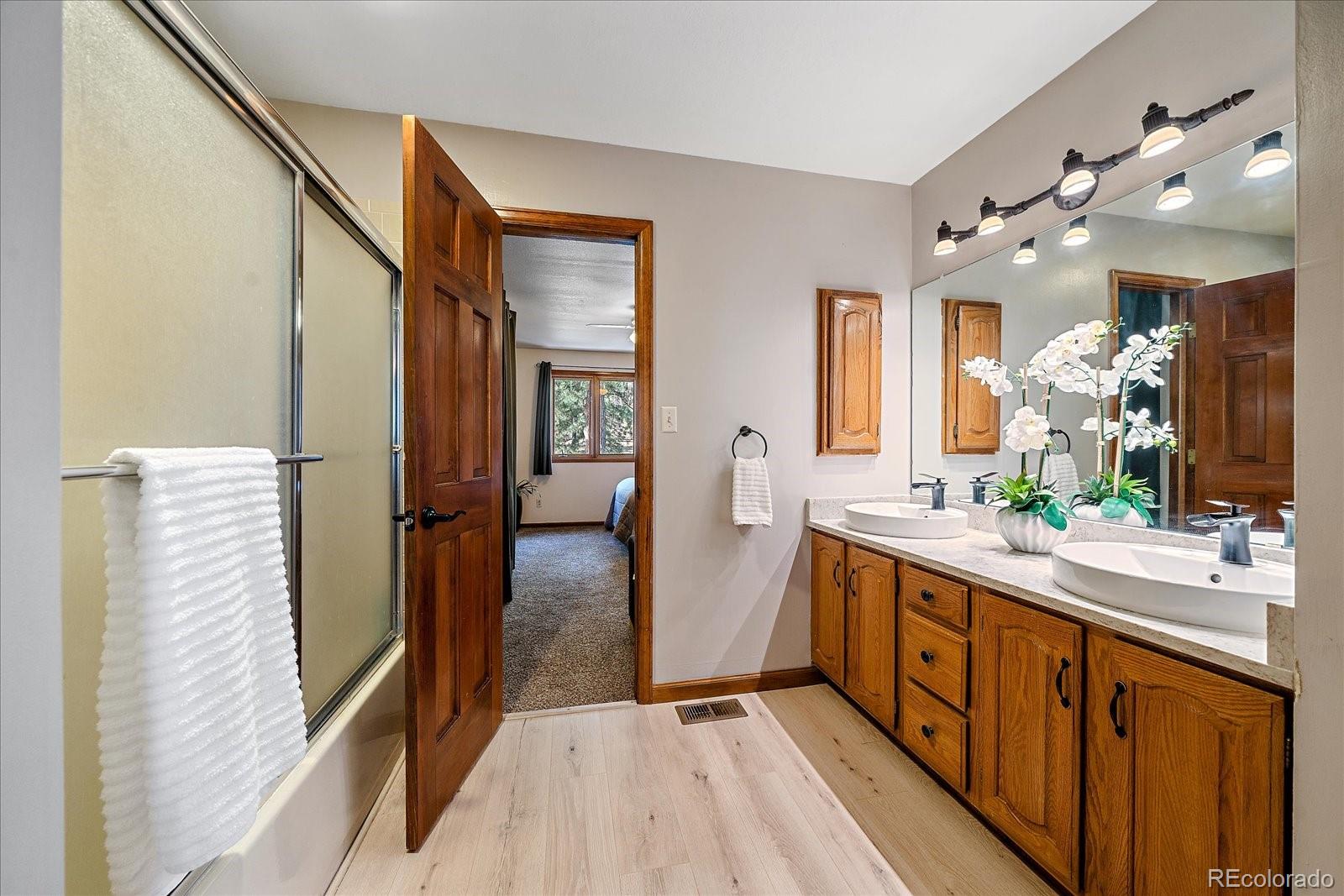 4059 Histead Way Evergreen, CO 80439 - Photo 27 of 37 a spacious bathroom with a double vanity sink a mirror and shower