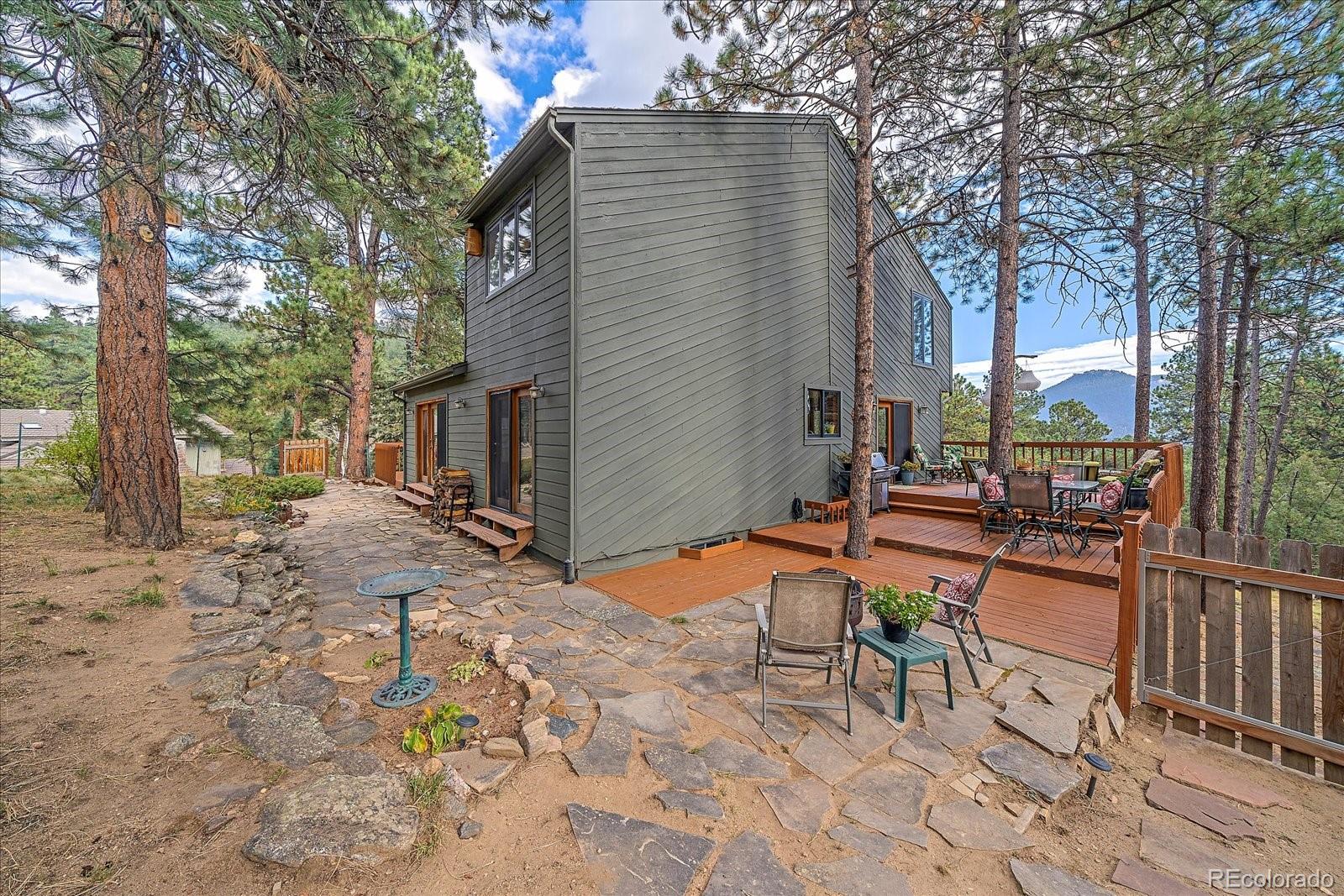 4059 Histead Way Evergreen, CO 80439 - Photo 35 of 37 a backyard of a house with table and chairs