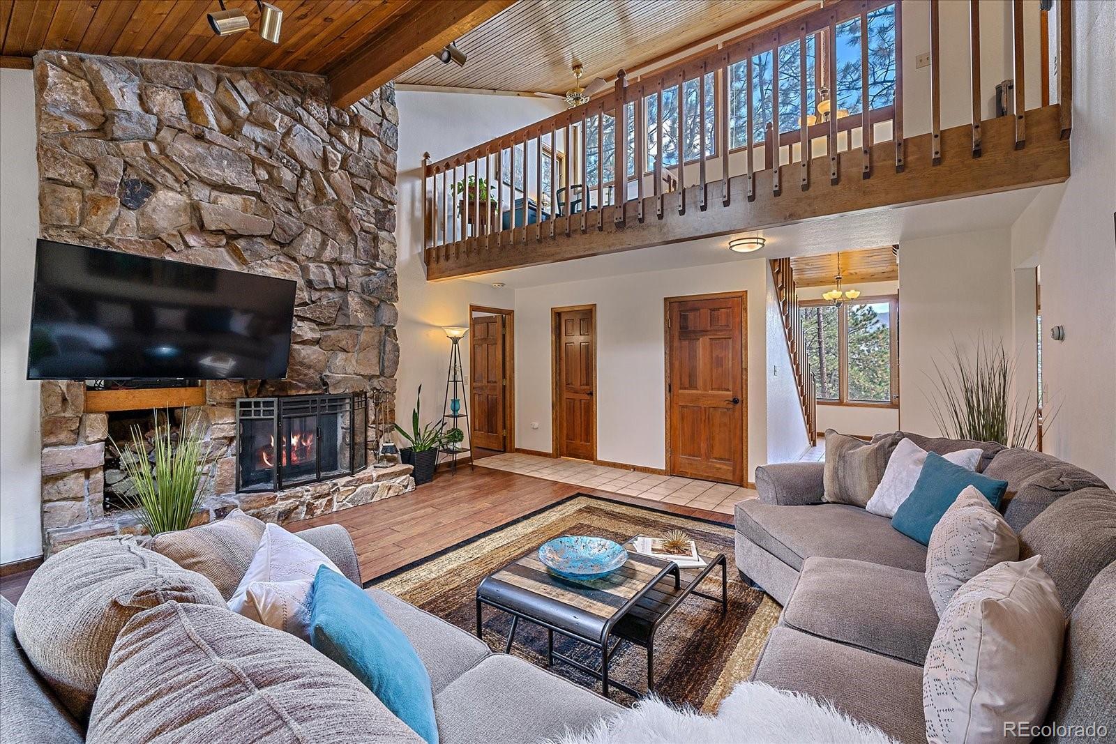 4059 Histead Way Evergreen, CO 80439 - Photo 6 of 37 a living room with furniture and a fireplace
