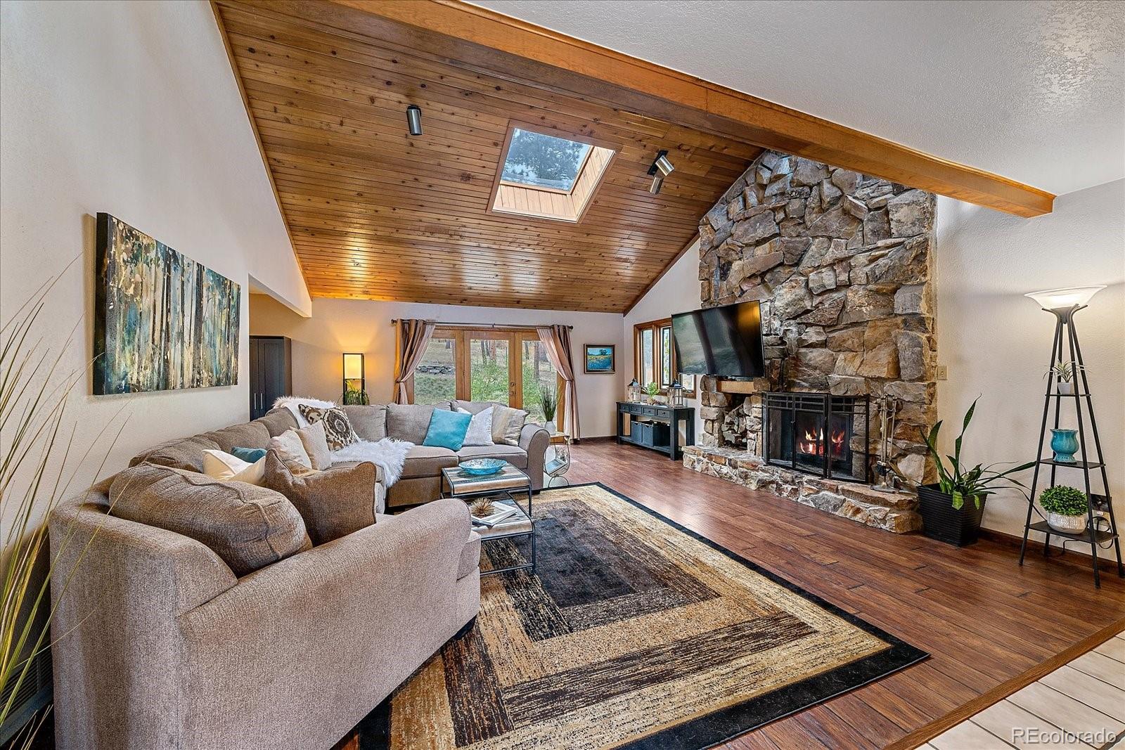 4059 Histead Way Evergreen, CO 80439 - Photo 8 of 37 a living room with furniture a fireplace and wooden floor