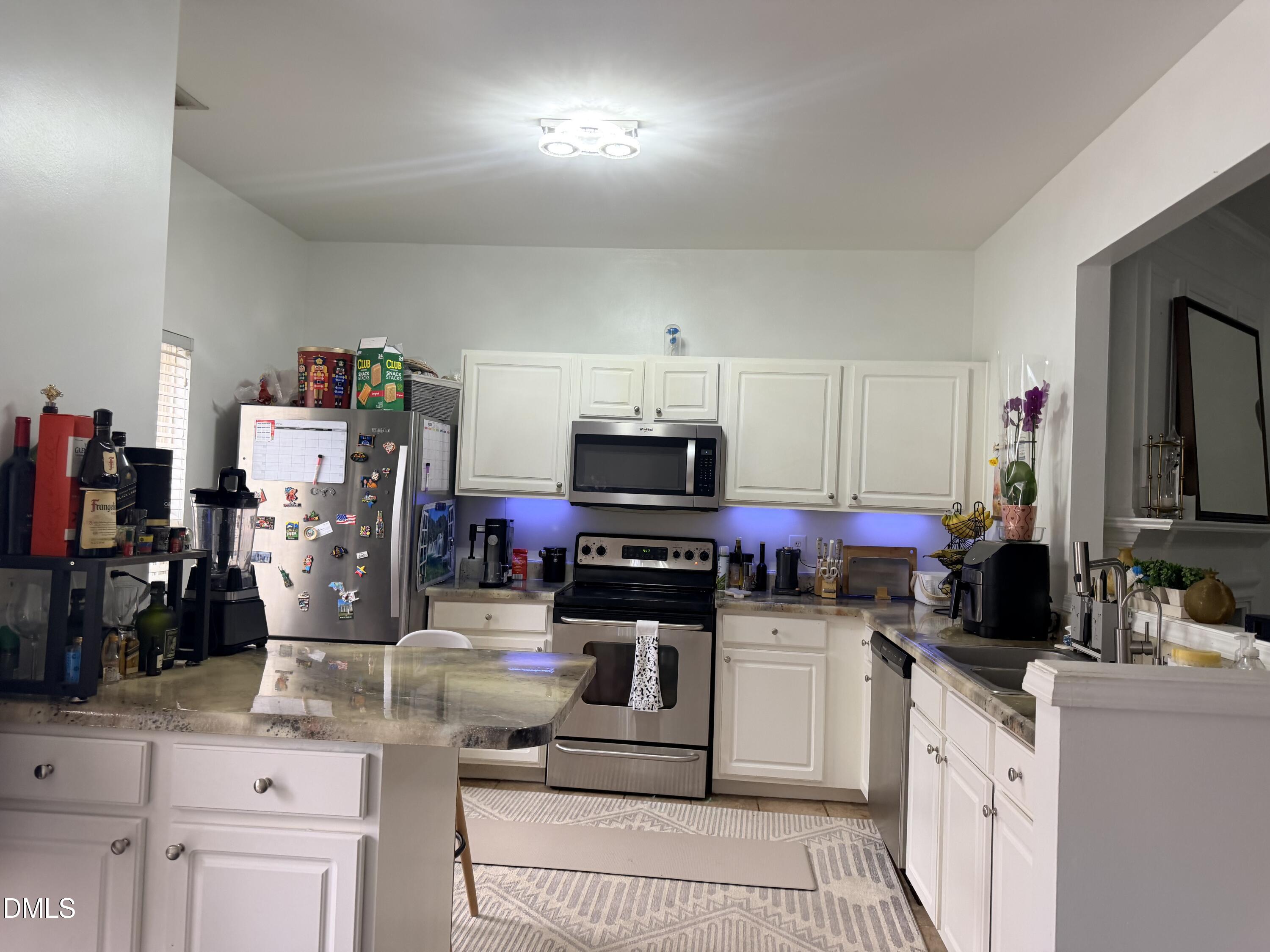 5345 Glen Canyon Road Raleigh, NC 27616 - Photo 6 of 21 a kitchen with stainless steel appliances kitchen island granite countertop a refrigerator and stove