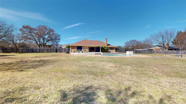a swimming pool with outdoor seating and yard