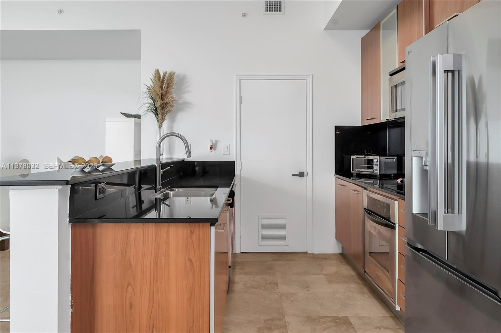9066 Southwest 73rd Court, Unit PH2402 Miami, FL 33156 - Photo 5 of 45 a kitchen with a refrigerator and a sink