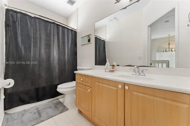 a bathroom with a sink a toilet a mirror and shower