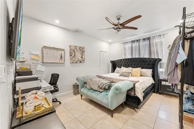 a bedroom with a bed and ceiling fan
