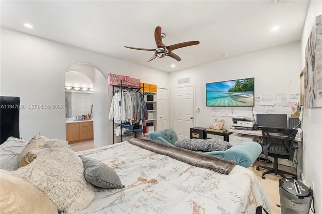 a bedroom with a bed large window and couch