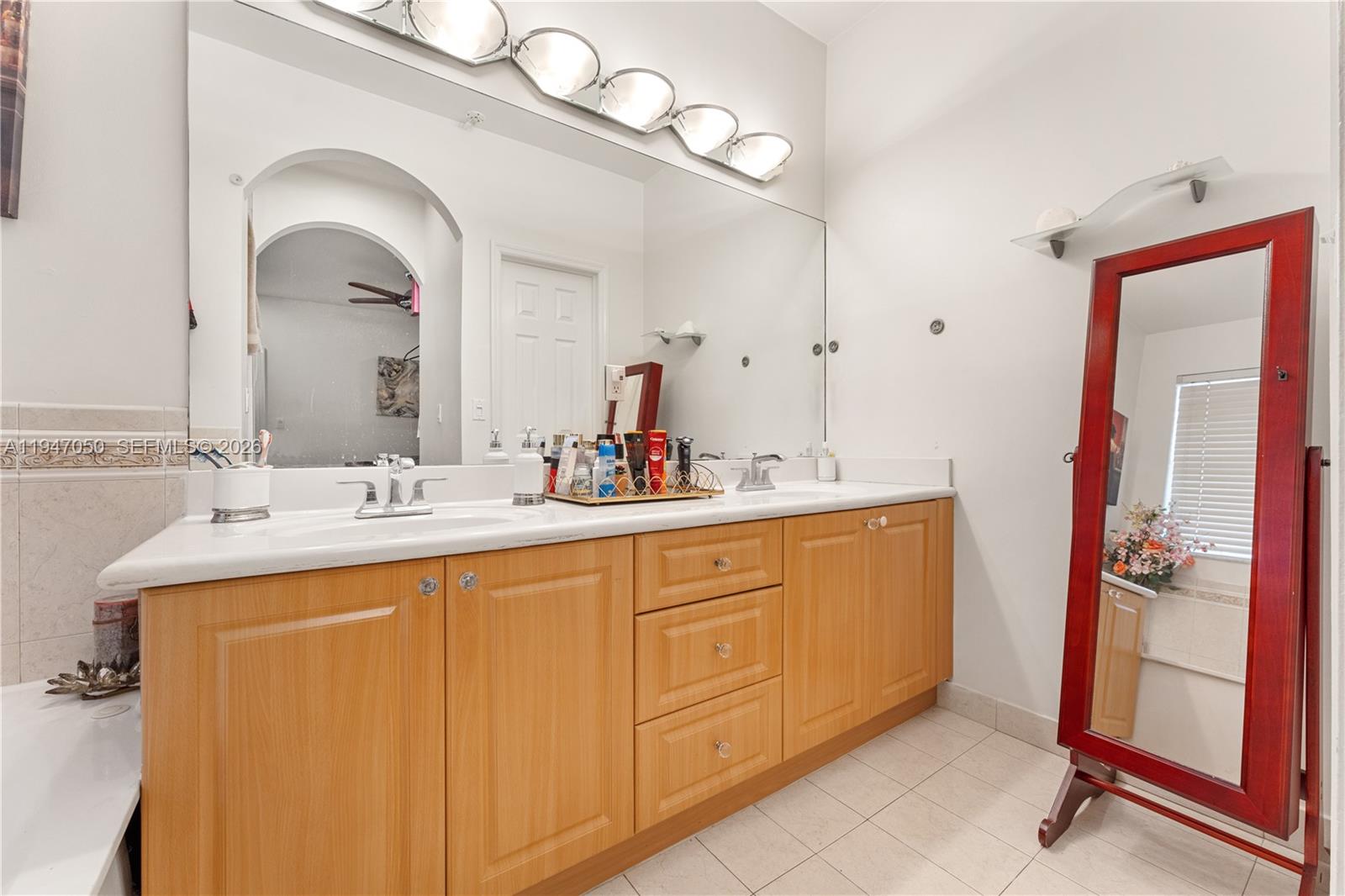 20032 Southwest 128th Court Miami, FL 33177 - Photo 21 of 28 a bathroom with a double vanity sink and a mirror