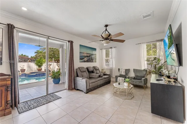 a living room with furniture a flat screen tv and a large window