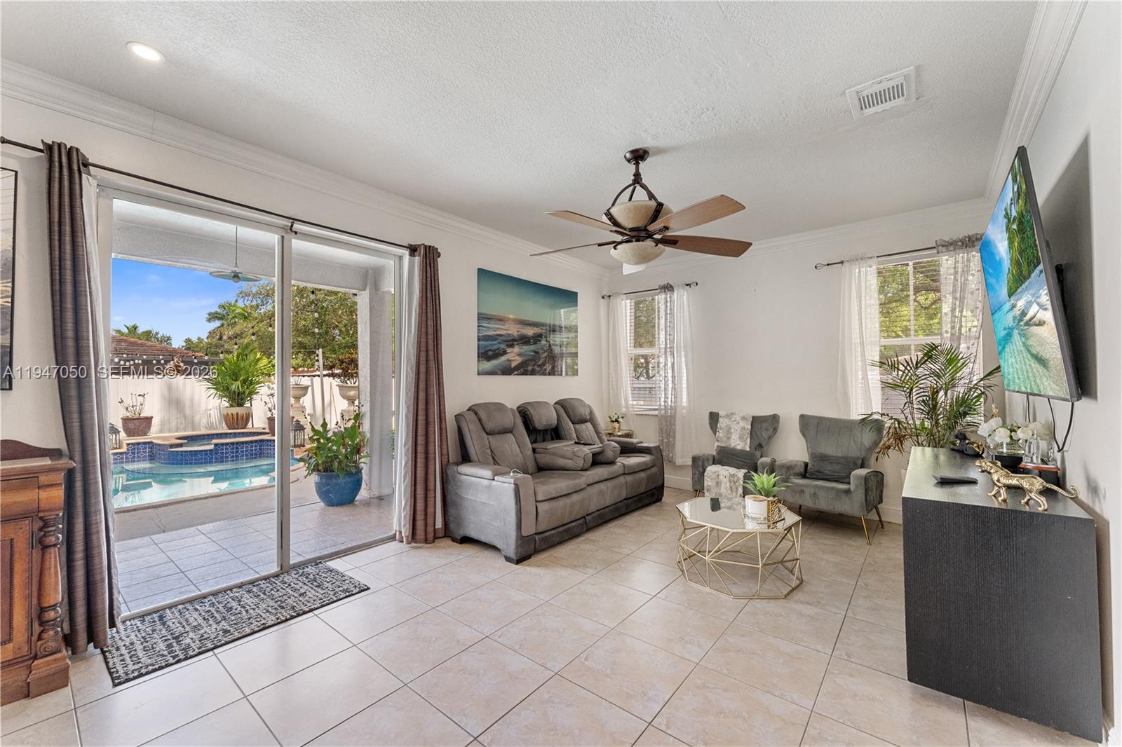 20032 Southwest 128th Court Miami, FL 33177 - Photo 8 of 28 a living room with furniture a flat screen tv and a large window