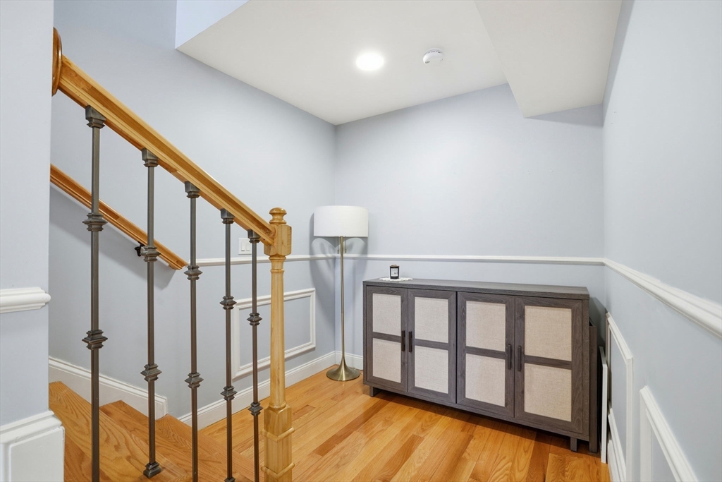 27 Pine Street, Unit 27 Dedham, MA 02026 - Photo 26 of 35 a view of staircase with lots of frames on wall and a window