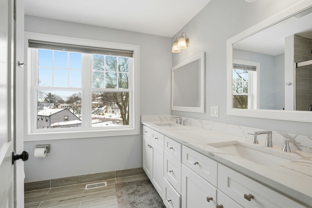 27 Pine Street, Unit 27 Dedham, MA 02026 - Photo 30 of 35 a bathroom with double vanity sink a mirror a window and a bathtub