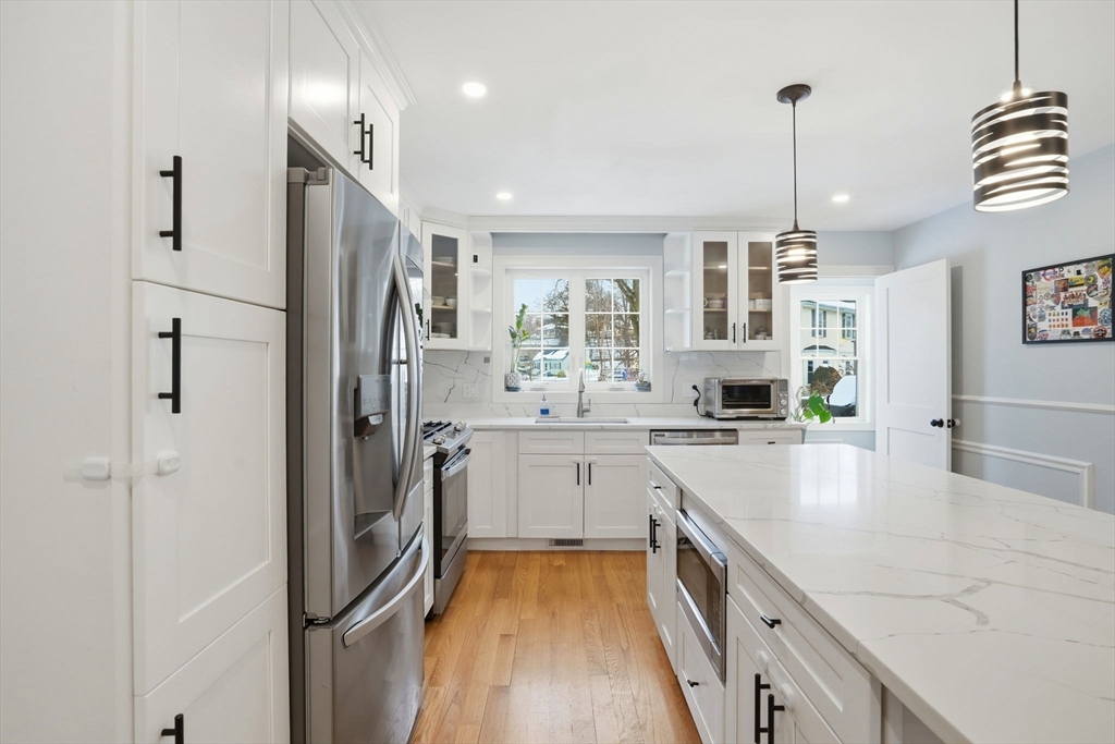 27 Pine Street, Unit 27 Dedham, MA 02026 - Photo 5 of 35 a kitchen with stainless steel appliances granite countertop a refrigerator a sink dishwasher a oven and white cabinets with wooden floor