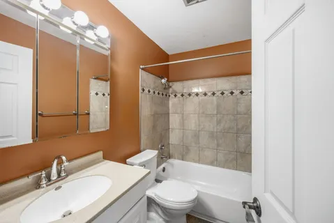 a bathroom with a sink vanity granite toilet and shower