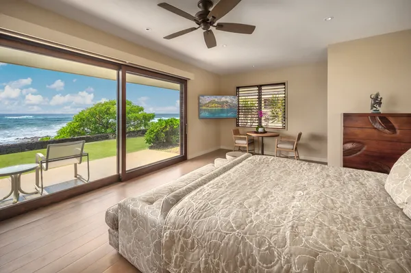 a bed sitting in a spacious bedroom next to a large window