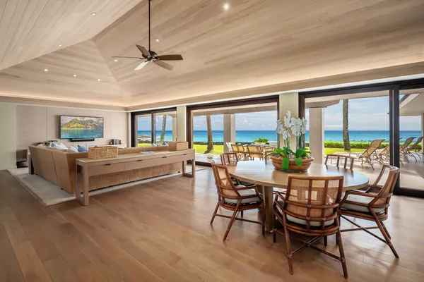 a dining room with furniture a chandelier and wooden floor