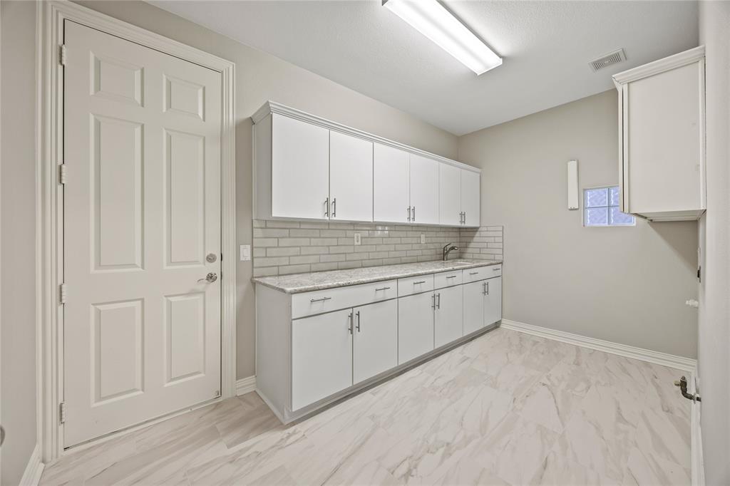10409 Countryside Drive Denton, TX 76207 - Photo 32 of 38 Washroom with light marble finish floors, granite countertops, and baseboards