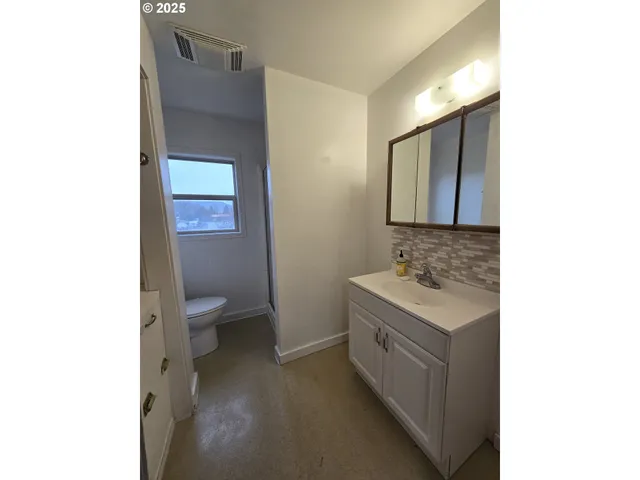 a spacious bathroom with a toilet sink and mirror
