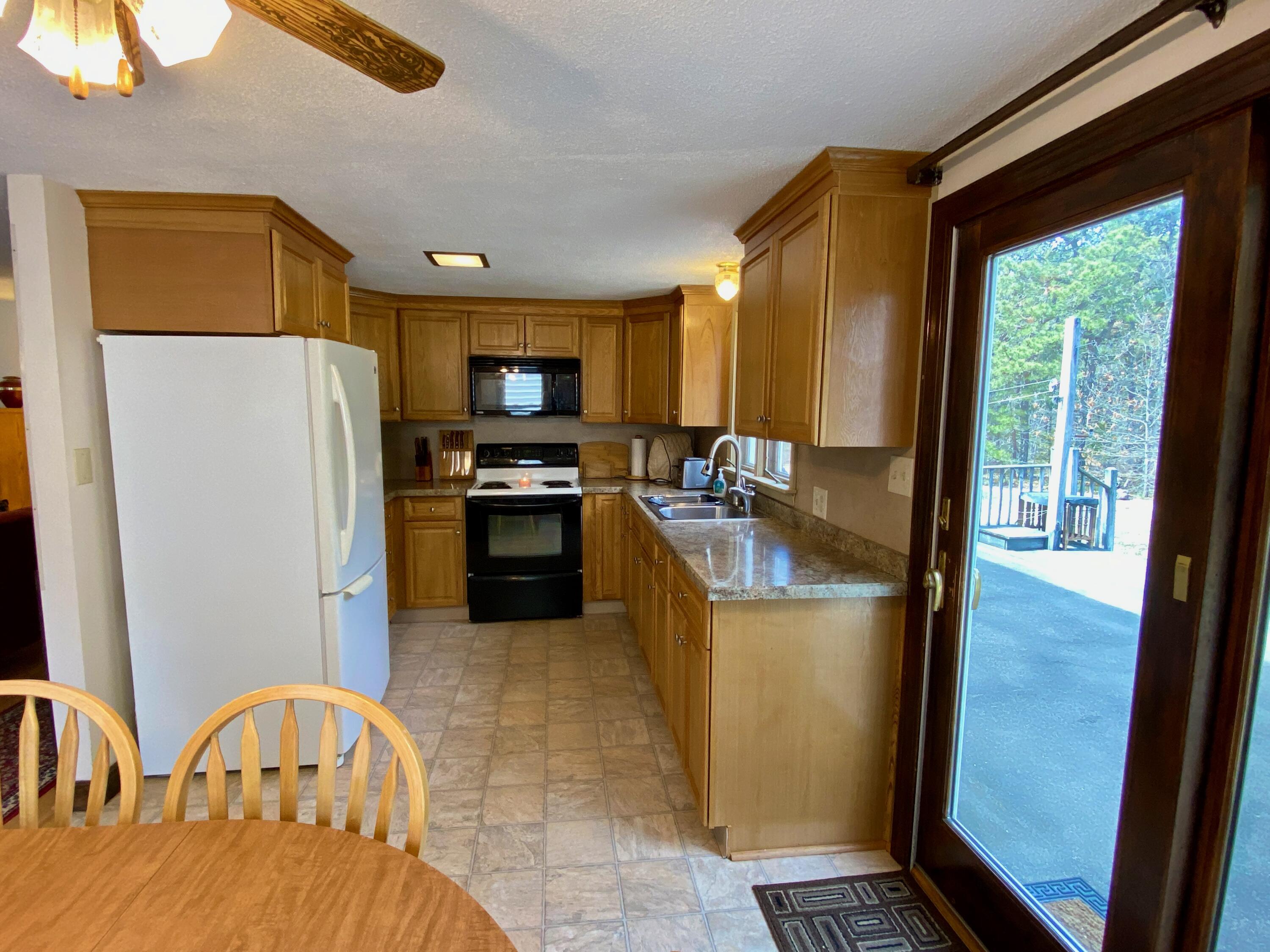 380 Foxwood Drive Eastham, MA 02642 - Photo 4 of 37 a kitchen with stainless steel appliances granite countertop a refrigerator a stove a sink a dining table and chairs