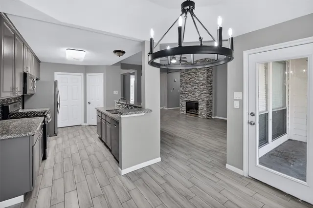 a kitchen with granite countertop stainless steel appliances a sink stove top oven and granite counter tops