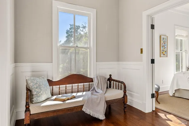 a view of a patio with couches table and chairs with potted plants and big trees