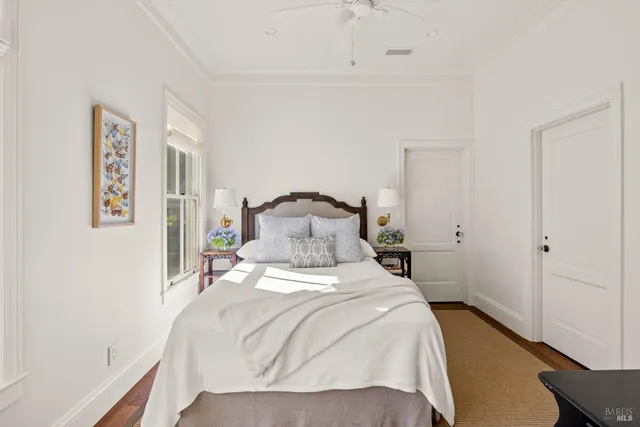 a view of a patio with couches and a table and chairs with wooden floor and fence
