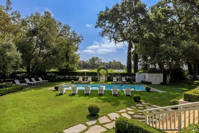 an aerial view of green landscape with trees houses and lake view