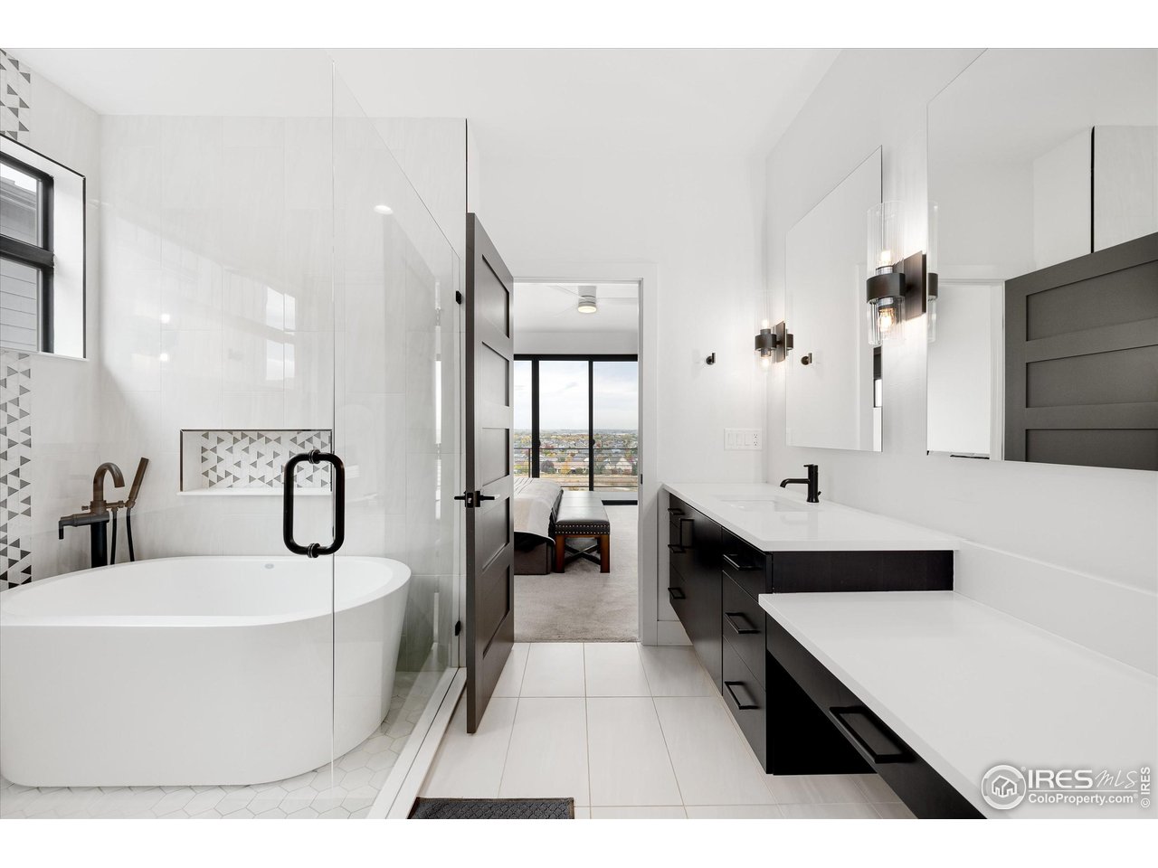 2145 Picture Point Drive Windsor, CO 80550 - Photo 16 of 40 a en suite bathroom with a double vanity sink a mirror a bathtub and shower