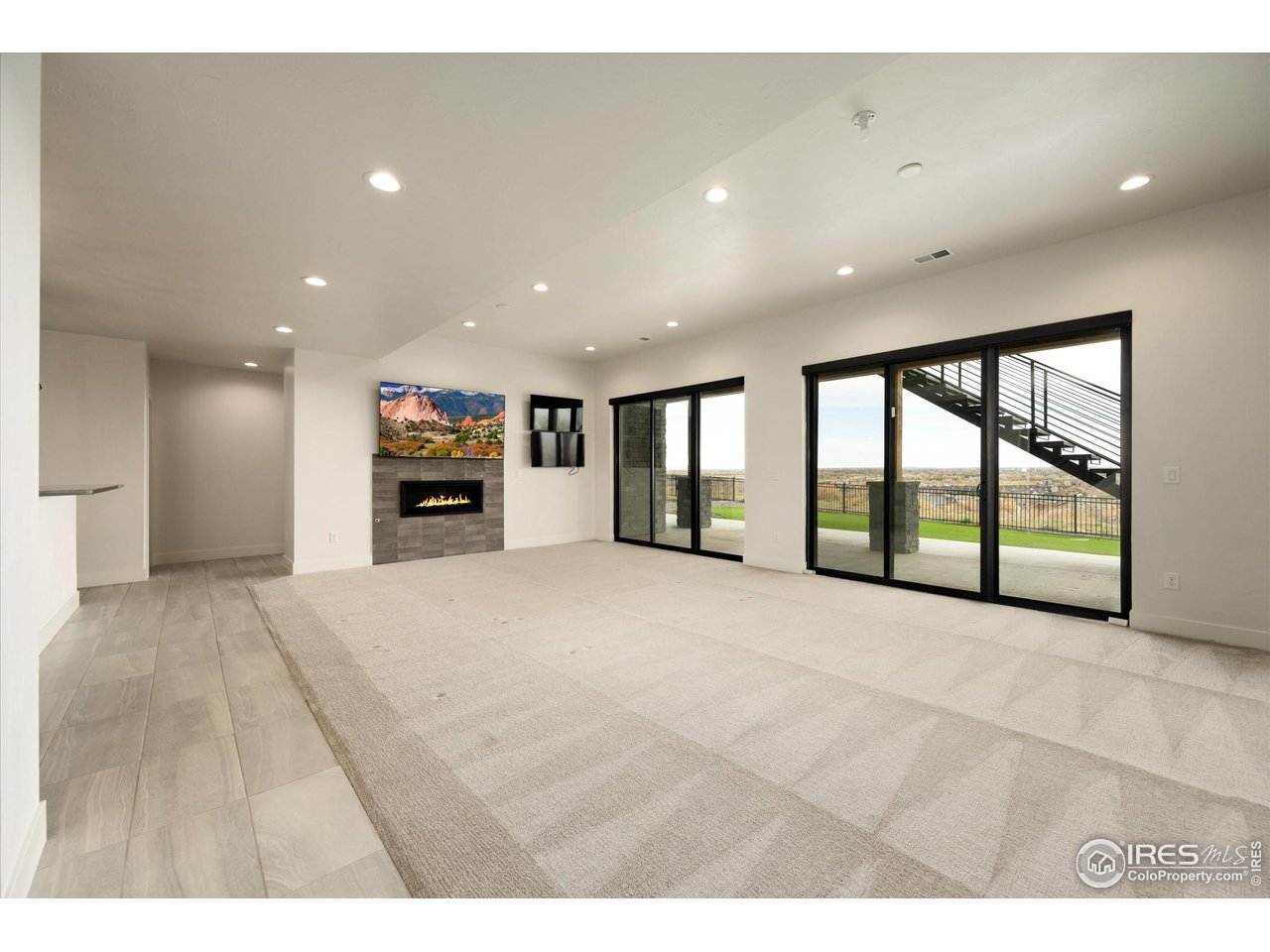 2145 Picture Point Drive Windsor, CO 80550 - Photo 26 of 40 a view of an empty room with a fireplace and a large window