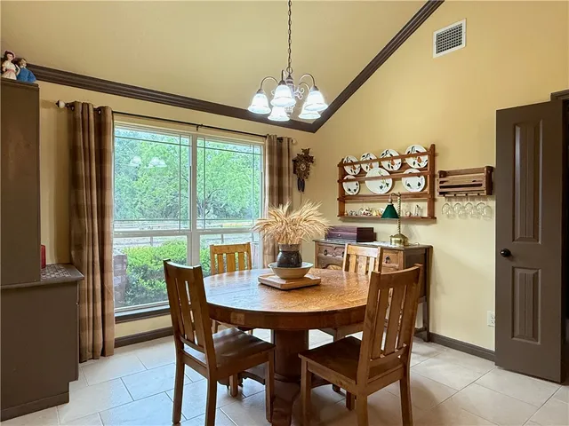 a dining room with furniture a chandelier and window