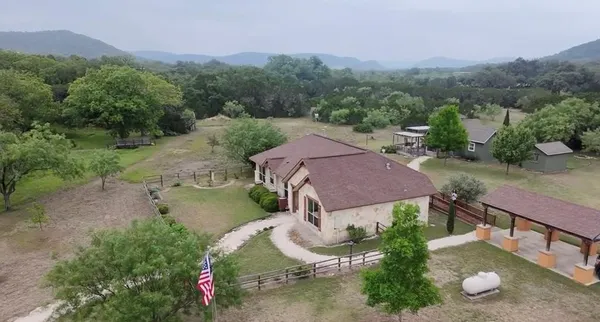 an aerial view of a house with pool garden and outdoor seating