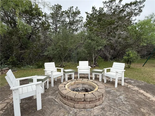 a view of a chairs and table in the back yard