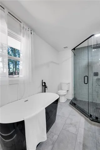 a spacious bathroom with a sink a toilet and a shower